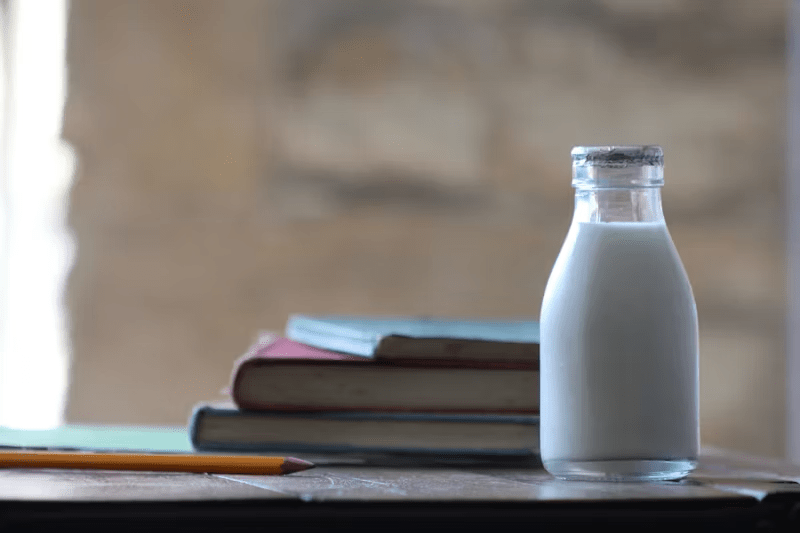 bottle of milk beside some books