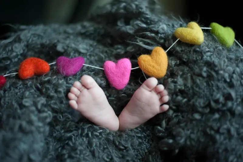 baby's feet under a heart string and a blanket