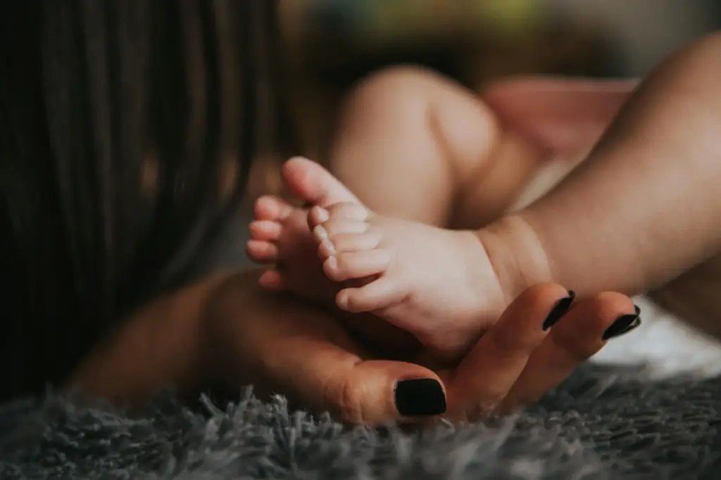 woman holding baby's feet